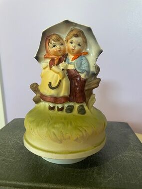Vintage Ceramic figurine music box featuring boy and girl under umbrella